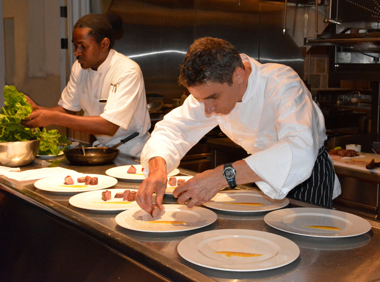 An image of Executive Chef Christophe Letard plating food at Belle Mont Farm
