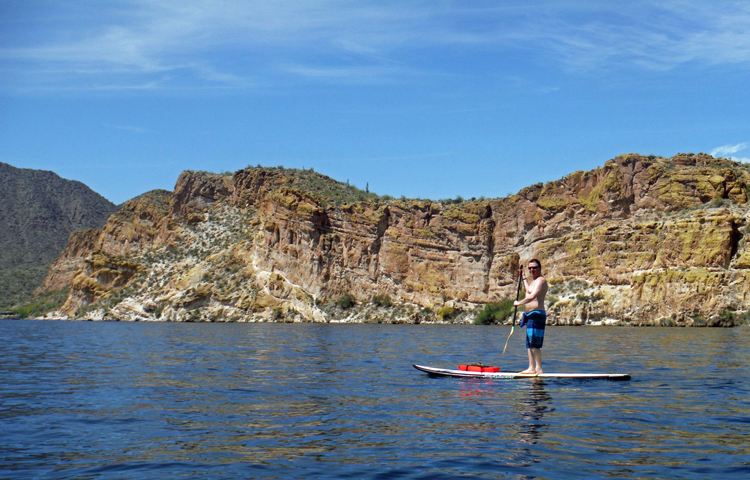 An image of a man on a stand-up paddleboard on Saguaro Lake