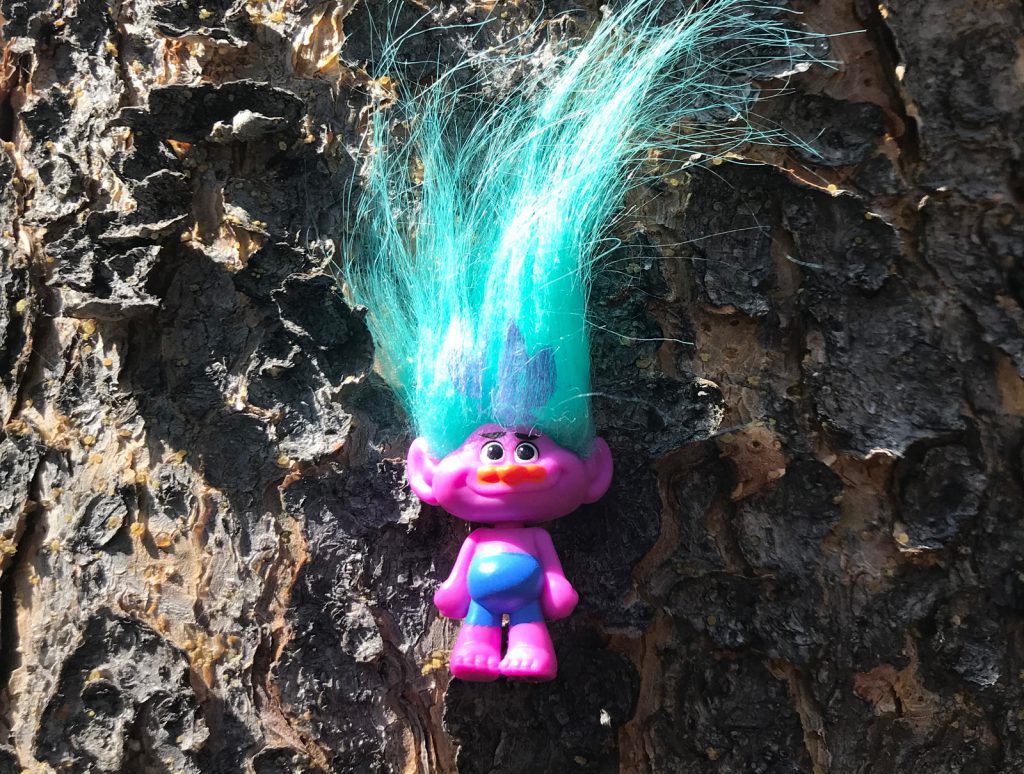 An image of a troll doll on a tree