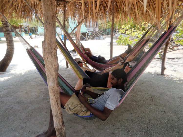 Four people relaxing in hammocks in Belize