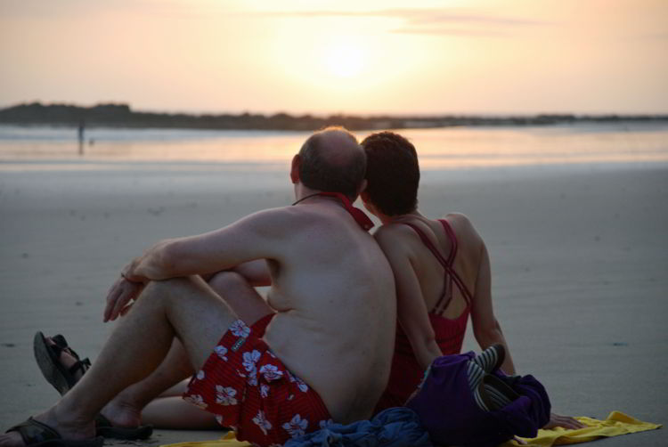 An image of a couple sitting on a beach in Costa Rica - Yoga Retreat Costa Rica 