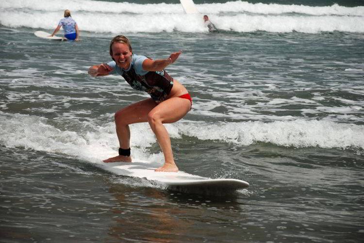 An image of a woman riding a wave at Anamaya Resort in Costa Rica - Yoga Retreat Costa Rica