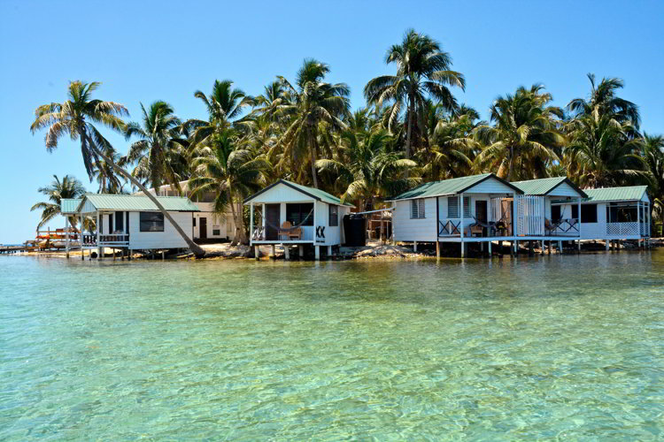 An image of five over water cabins of Tobacco Caye Paradise on the island of Tobacco Caye in Belize