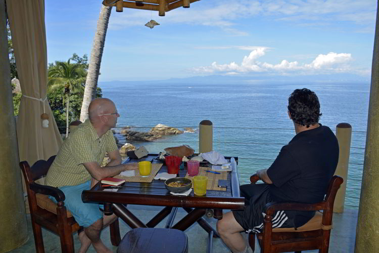 An image of two men sitting at a dining table and looking at the view at Casa Pericos in Yelapa - Jalisco, Mexico - Yelapa Beach