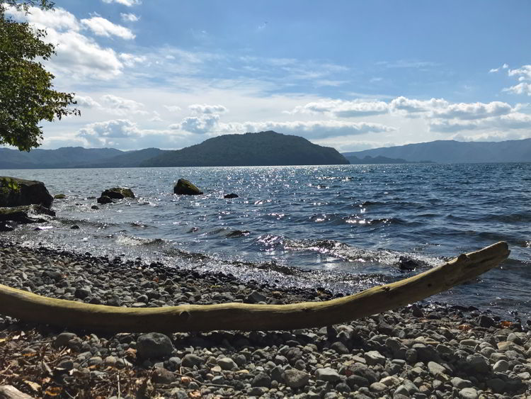 An image of the sun reflecting off of Lake Towada near Aomori, Japan - Lake Towada and Oirase Gorge