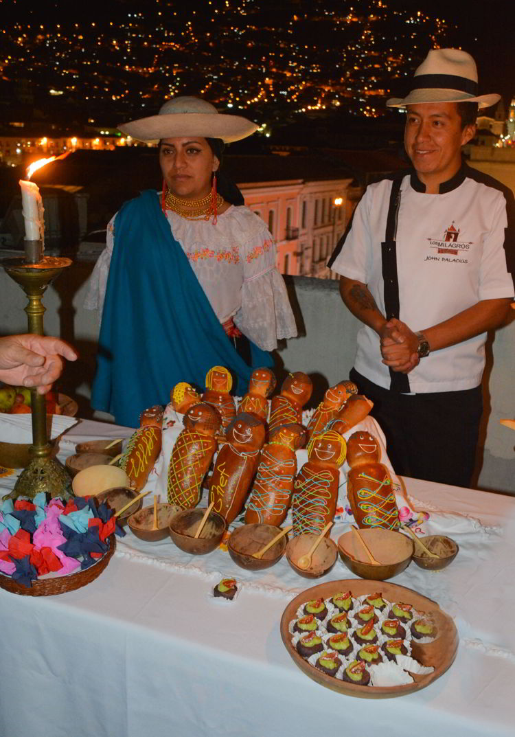 An image of two people standing behind a table filled with bread babies in Quito, Ecuador - Day of the Dead Festival -Dia de los Muertos 
