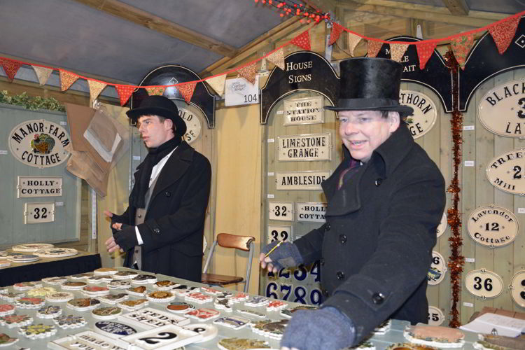 An image of two craft vendors in historic costume at the Lincoln Christmas Market in Lincolnshire, England