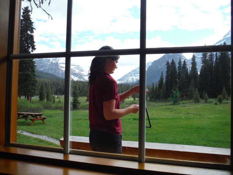 An image of someone dinging the dinner triangle to signal dinner is ready at Shadow Lake Lodge