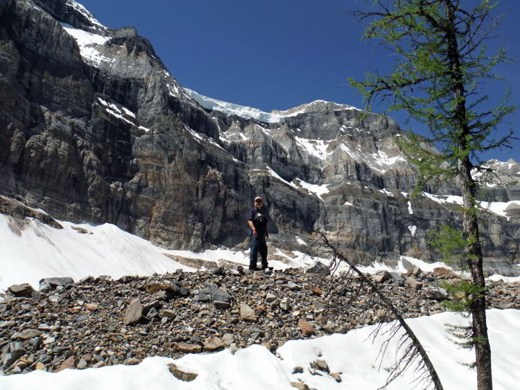 An image of a man standing on a rocky moraine in the backcountry of Banff National Park - Shadow Lake Lodge