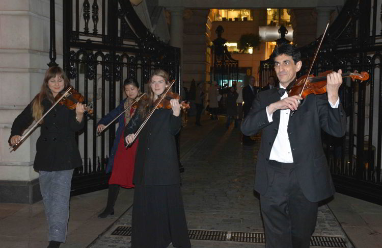 An image of some musicians playing violins - best Christmas markets