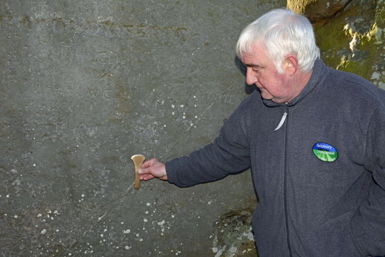 An image of guide Pat Shelley pointing to a stone at the Stonehenge site near Salisbury, UK - Stonehenge inner circle tours