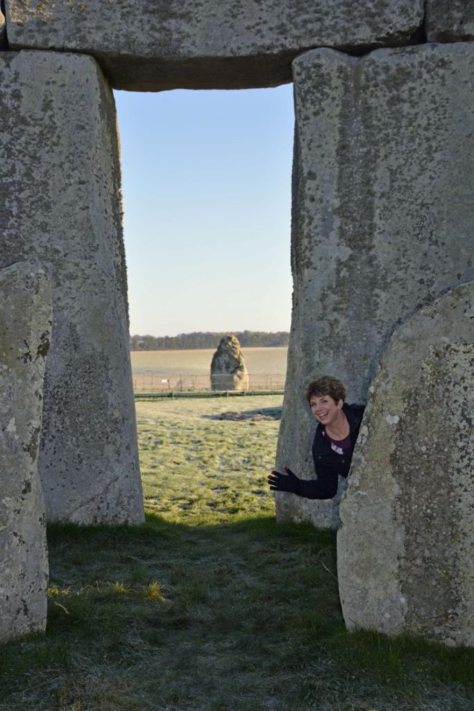 An image of a person beside the inner circle rocks at Stonehenge near Salisbury, UK - Stonehenge inner circle tours