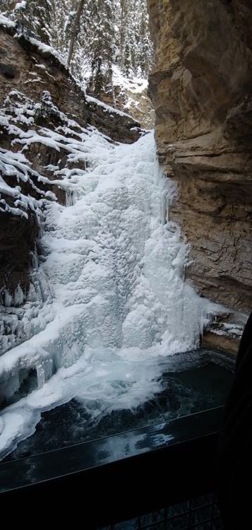 An image of the frozen lower falls in Johnston Canyon in  Banff National Park, Alberta - Johnston Canyon Winter Hike and ink pots hike