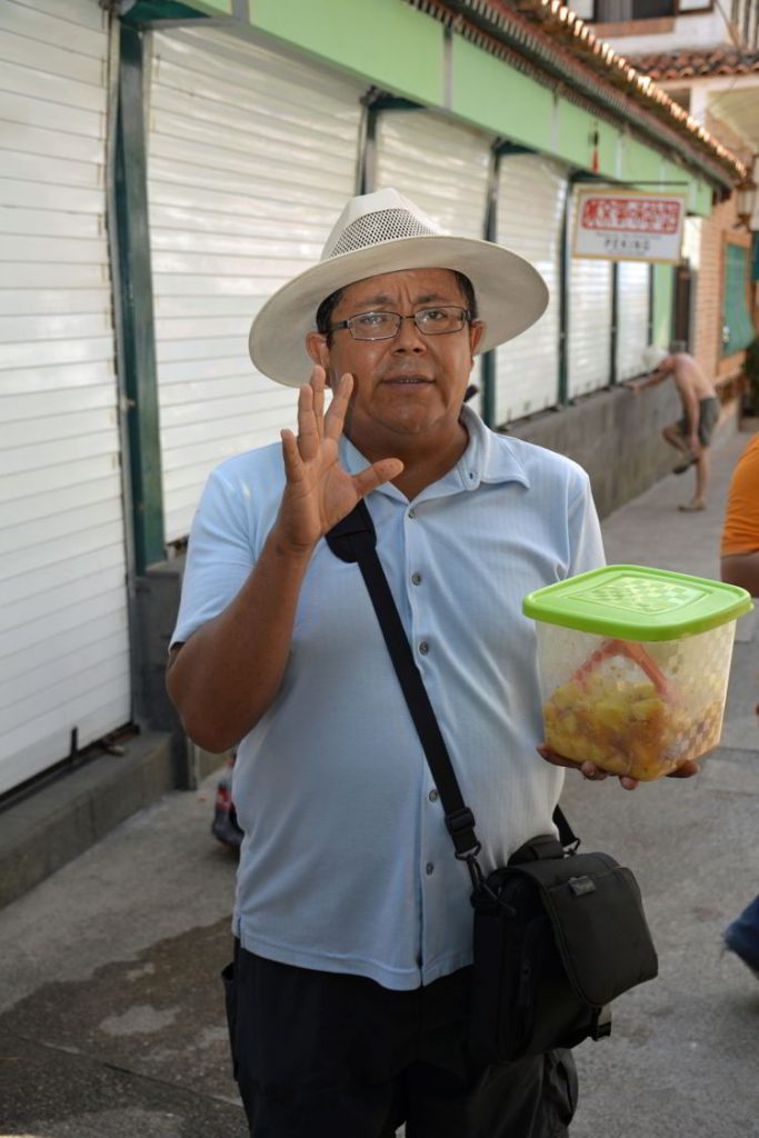 An image of a Vallarta Food Tours guide holding a container of salsa in Puerto Vallarta, Mexico - The best tacos in Puerto Vallarta
