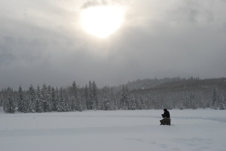 An image of a person sitting in a snowy field in Jasper National Park in Alberta - Alberta Hikes help you beat the winter blues