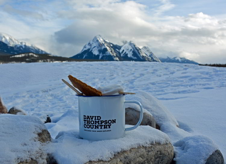An image of a David Thompson Tourism mug on a rock at Preacher's Point near Abraham Lake, Alberta