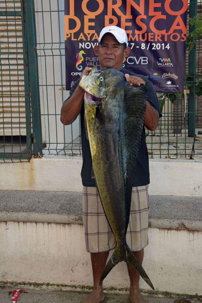 An image of a fisherman holding a fresh-caught mahi-mahi in Puerto Vallarta, Mexico - the best tacos in Puerto Vallarta