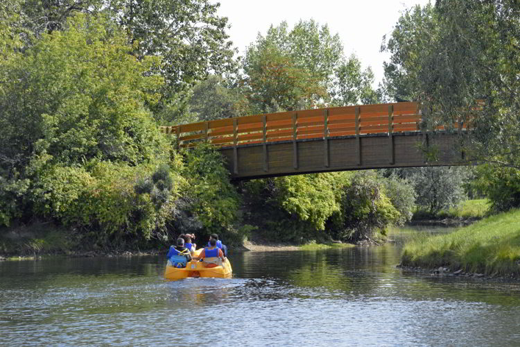 An image of two people in a peddle boat at Bower Ponds in Red Deer, Alberta, Canada. 