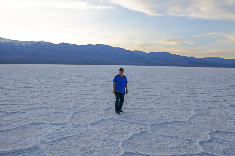 An image of a man standing on the Badwater Basin salt flats in Death Valley National Park in California - visiting Death Valley