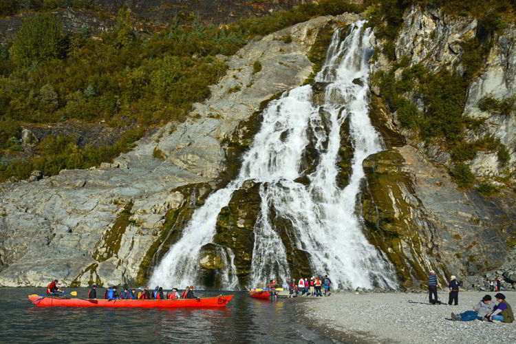 An image of canoes and people in front of Nugget Falls near Mendenhall Glacier near Juneau, Alaska