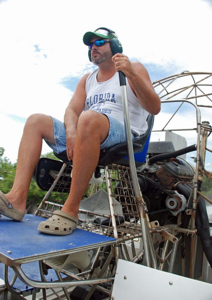 An image of a captain driving an airboat in the Florida Everglades