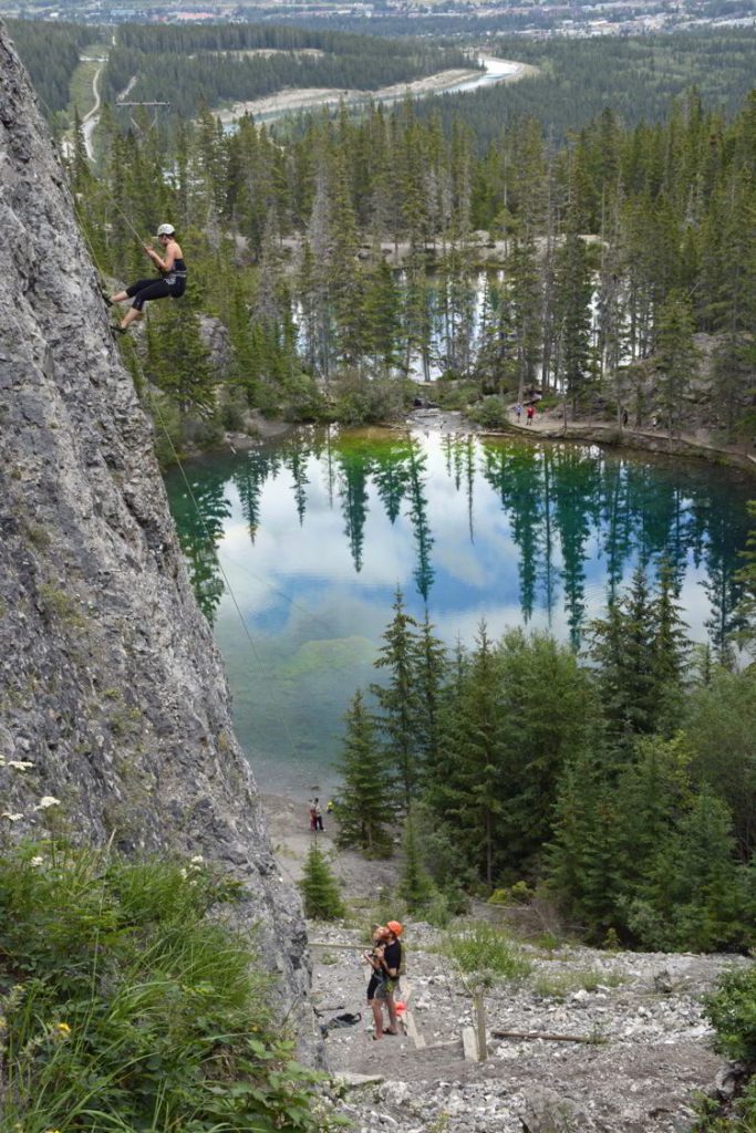 An image of some rock climbers scaling a cliff face above the Grassi Lakes near Canmore, Alberta in the Canadian Rockies. 