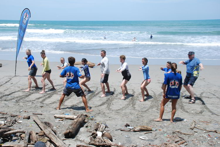 An image of a group of people practicing their surf stance at surf school in Costa Rica.