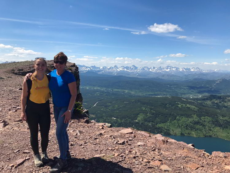 An image of two women standing at the top of Table Mountain in Alberta, Canada. 