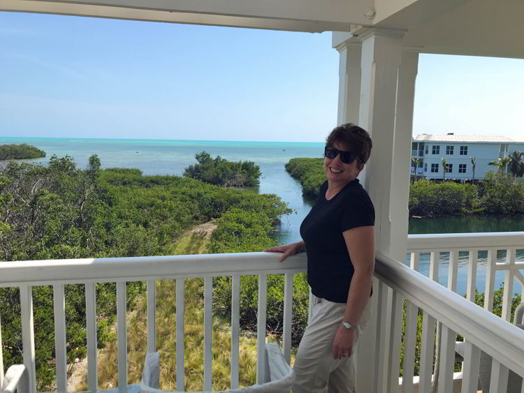 An image of a woman standing on a balcony at Oceans Edge Resort and Marina in Key West, Florida. 