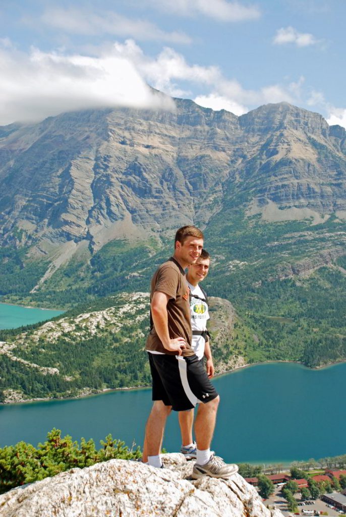 An image of two young men standing at the top of the Bear's Hump hike in Waterton Lakes National Park in Alberta, Canada. 