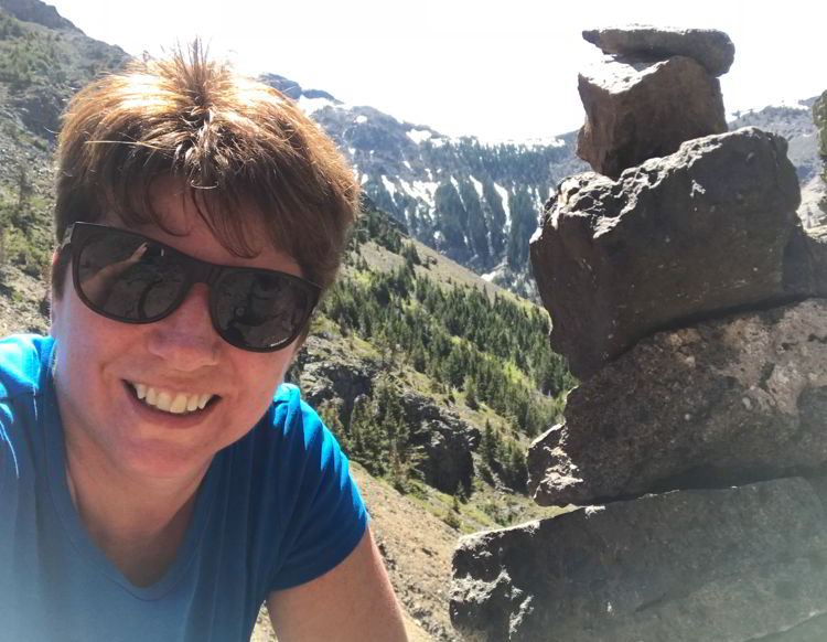 An image of a woman and an inukshuk on the Table Mountain Alberta hike. 