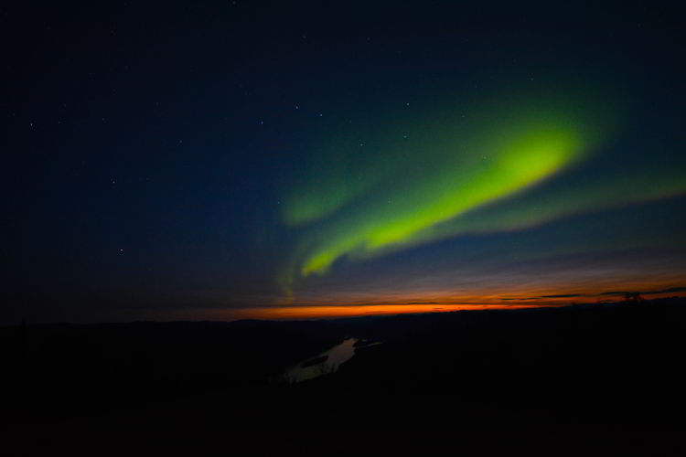 An image of a red and green aurora near Dawson City, Yukon in August. 