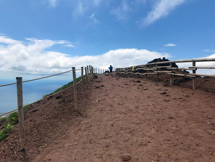 An image of the trail and a person hiking Mt Vesuvius in Naples, Italy.