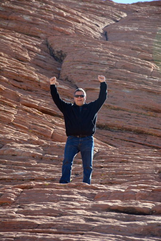 An image of a man standing on the red rocks at Red Rock Canyon Conservation Area outside Las Vegas, Nevada. 