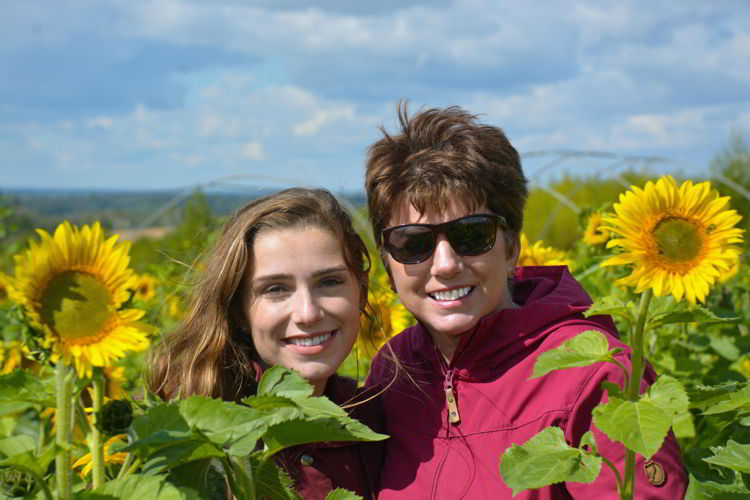 An image of a mother a daughter in a sunflower field at Bowden Sunmaze in Bowden, Alberta, Canada. 