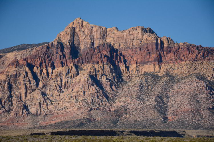 An image of a mountain with a red streak running through it at the Red Rock Conservation Area outside Las Vegas, Nevada. 