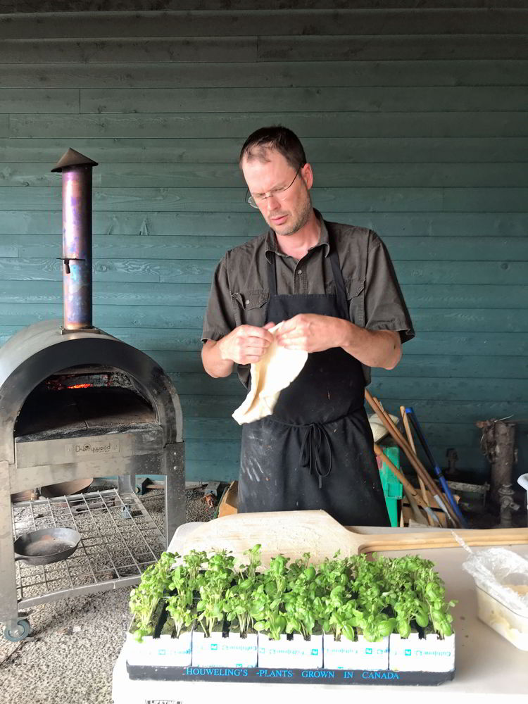 An image of a man making pizza at Broxburn Vegetables and Cafe in Lethbridge, Alberta. 