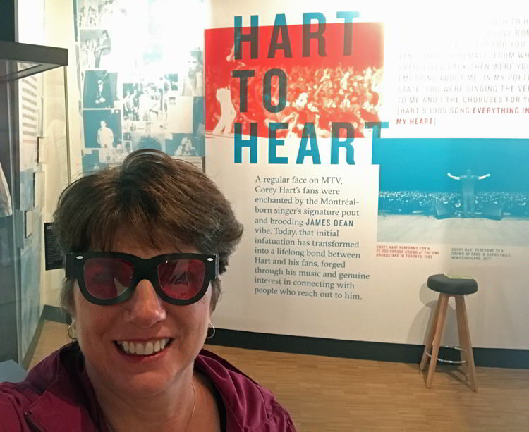 An image of a woman taking a selfie at the Corey Hart exhibit at National Music Centre in Calgary, Alberta, Canada.