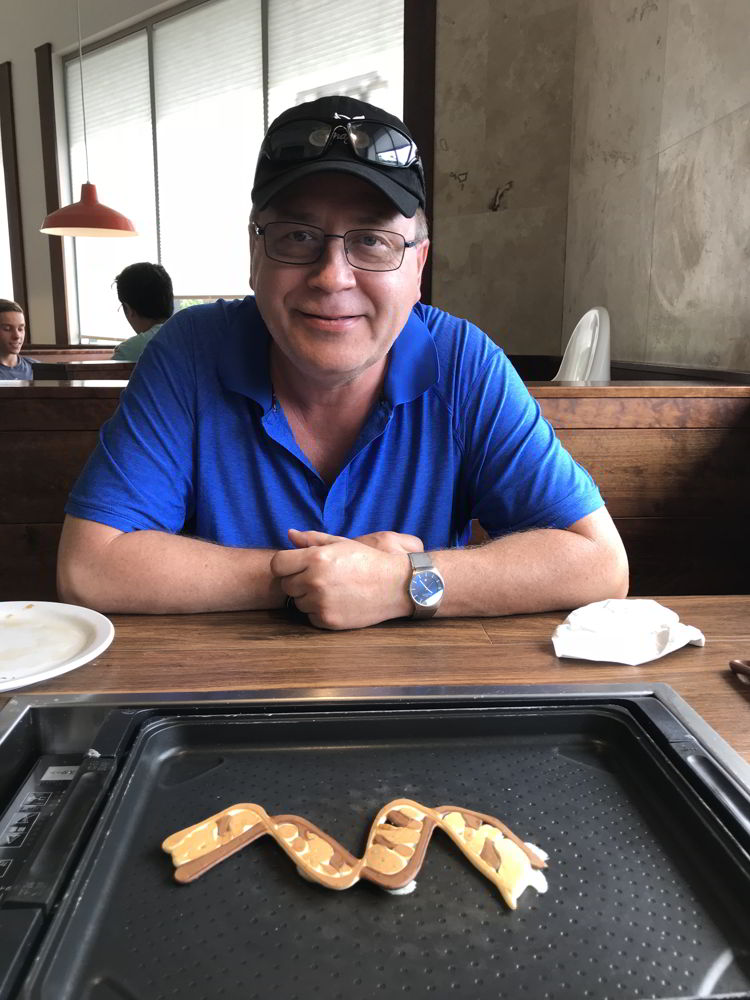 An image of a man with the pancake art he created at Slappy Cakes Restaurant in Kāʻanapali, Maui. 