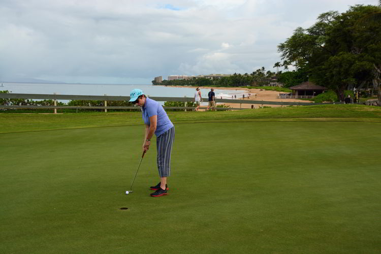 An image of a woman golfing at Kāʻanapali Golf Course. 