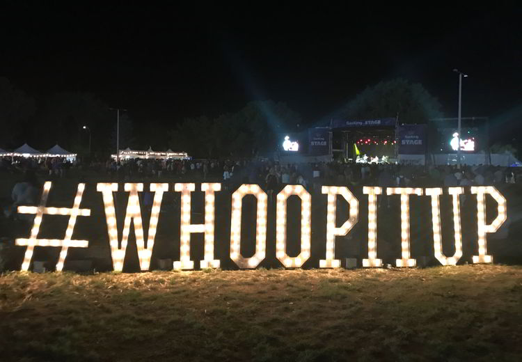 An image of the Whoop it up sign lit up at Whoop-up days in Lethbridge, Alberta. 