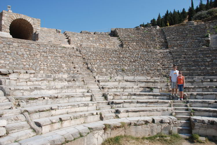 An image of two people standing on the steps of the great theatre in Ephesus. 