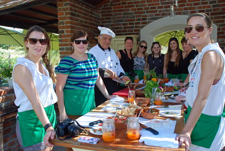 An image of a group of people in enjoying a cooking class at Flora Farms Field Kitchen in Cabo San Lucas, Mexico. 