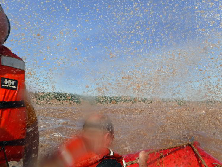 An image of water splashing into the zodiac boat while tidal bore rafting on the Schubenacadie River in Nova Scotia.