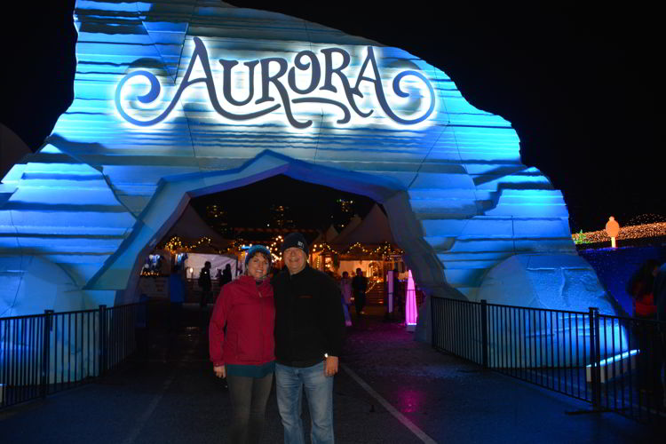 An image of two people standing in front of the entrance gate at the Aurora Winter Festival in Vancouver, BC, Canada. 