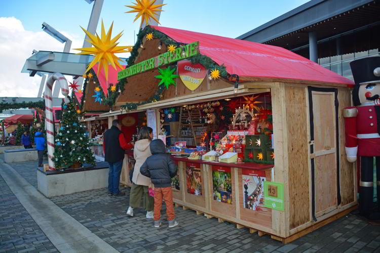 An image of people shopping at a booth at the German Christmas Market in Vancouver, BC, Canada. 