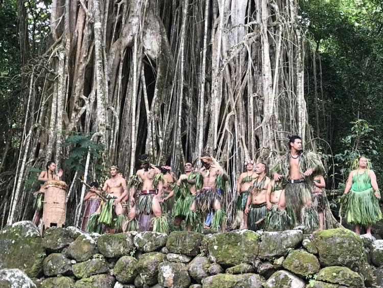 An image of dancers performing in front of a banyan tree on the island of Nuka Hiva in the Marquesas Islands of French Polynesia. 