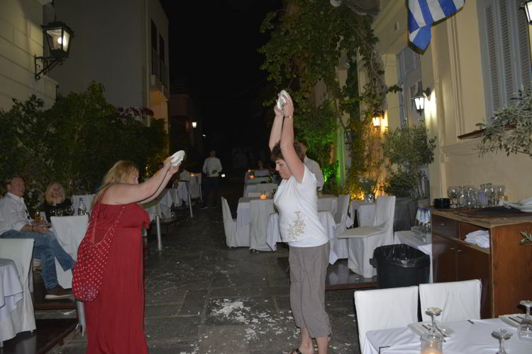 An image of two women braking plates at Adrianos restaurant in Athens, Greece. 
