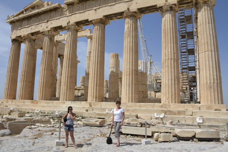 An image of two women standing in front of the Parthenon in Athens, Greece. 