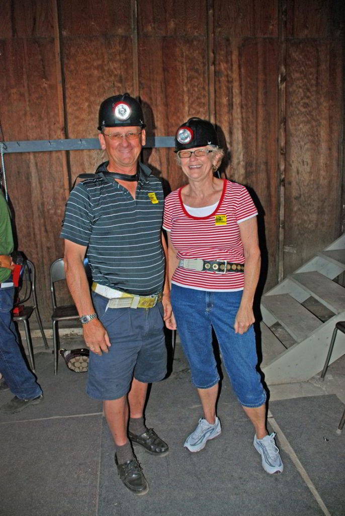 An image of a couple wearing hardhats for a tour of Atlas Coal Mine. 